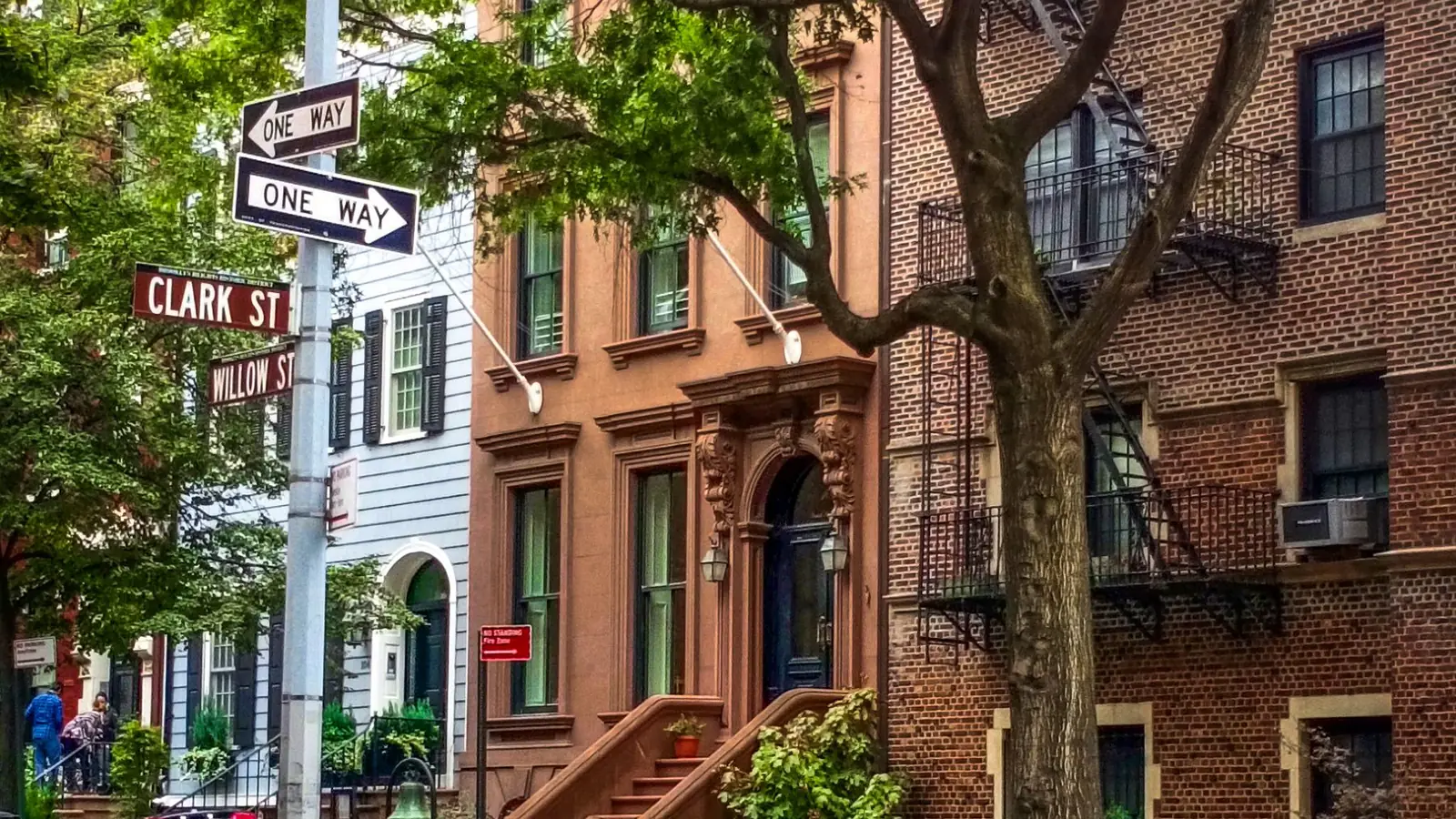 Calle de Brooklyn con casas de ladrillo rojo y escaleras de entrada